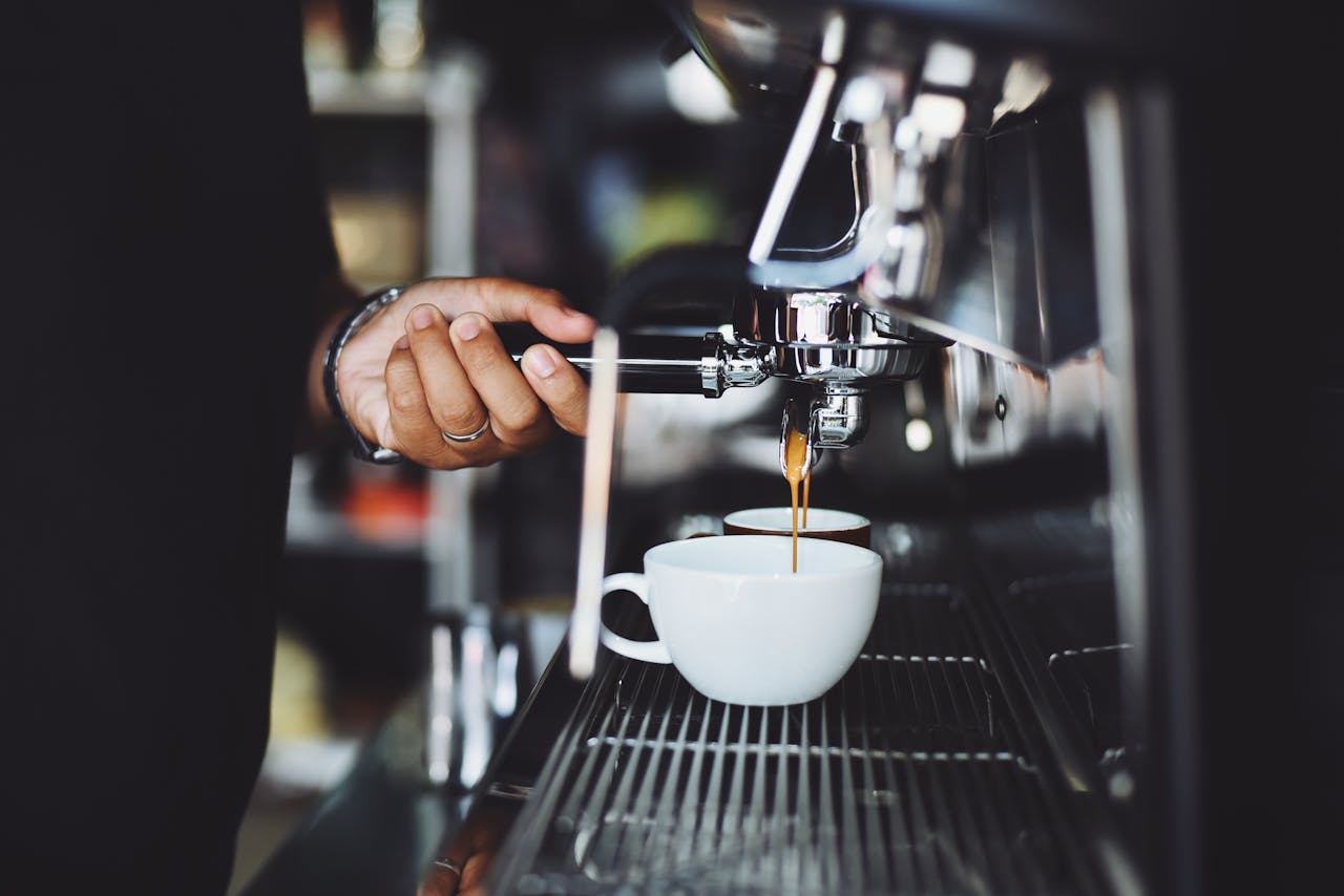 heros-img Close-up of a barista preparing espresso in a café using a machine